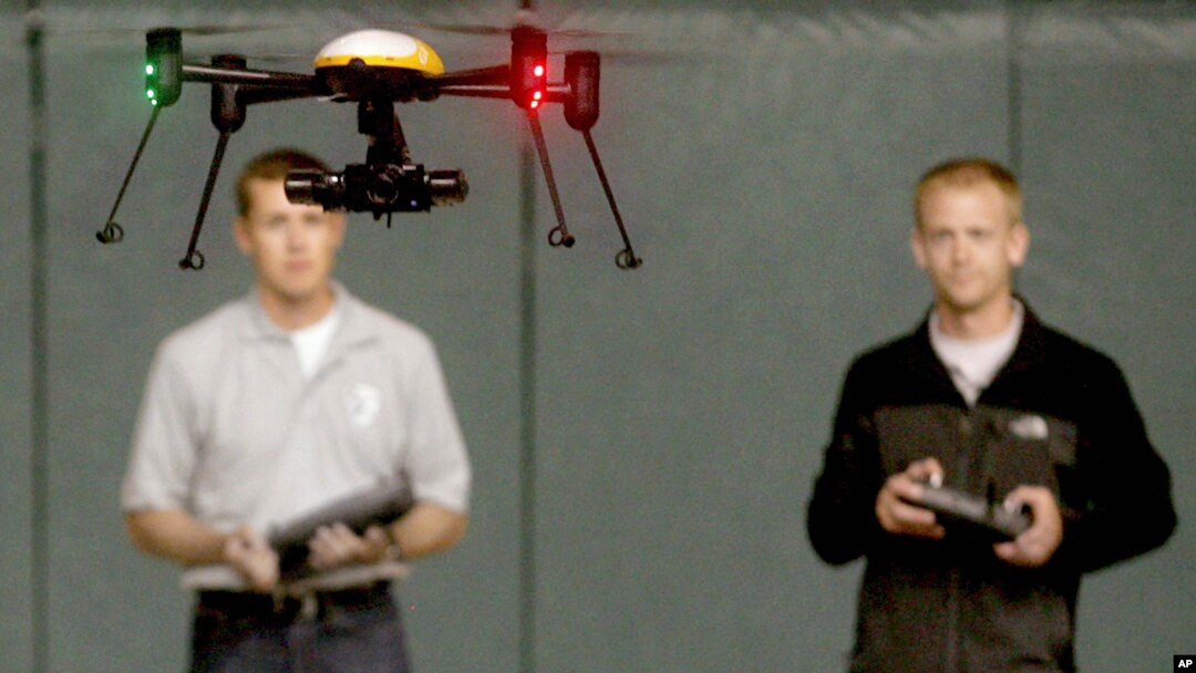 FILE - Students at the University of North Dakota in Grand Forks remotely pilot a drone during a demonstration, June 24, 2014. The Federal Aviation Administration now requires drone registration. 