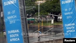 A woman walks past the International Convention Center where the 5th BRICS Summit will be held, in Durban, South Africa, Mar. 25, 2013. 