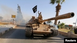 Militant Islamist fighters on a tank take part in a military parade along the streets of northern Raqqa province, Syria, in 2014. (Reuters)