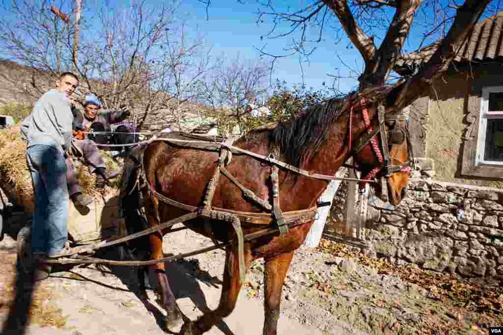 Locals on a Sunday afternoon drive on the main street in Old Orhei village. (Vera Undritz for VOA)