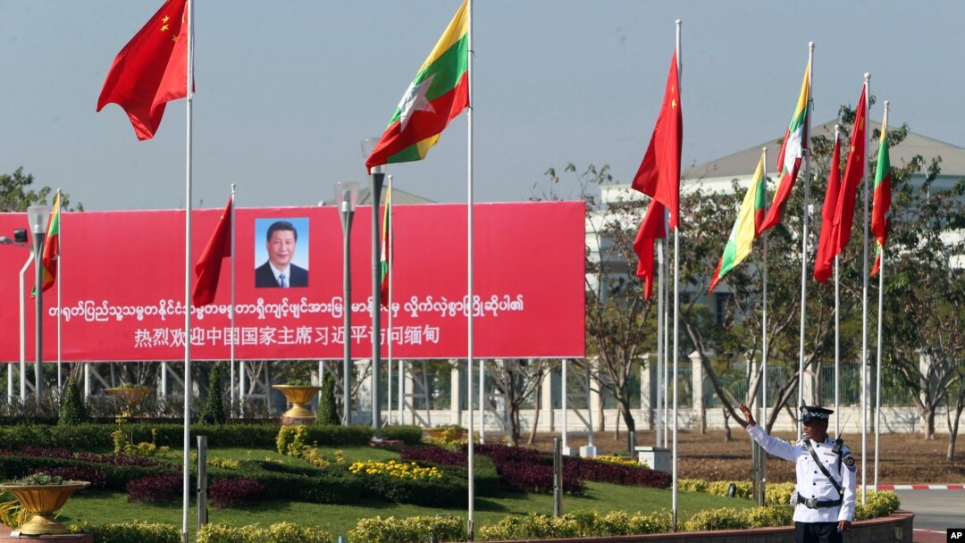 A traffic police stands on a road as he clears a road near a welcoming billboard to Chinese President Xi Jinping Friday, Jan. 17, 2020, in Naypyitaw, Myanmar. 