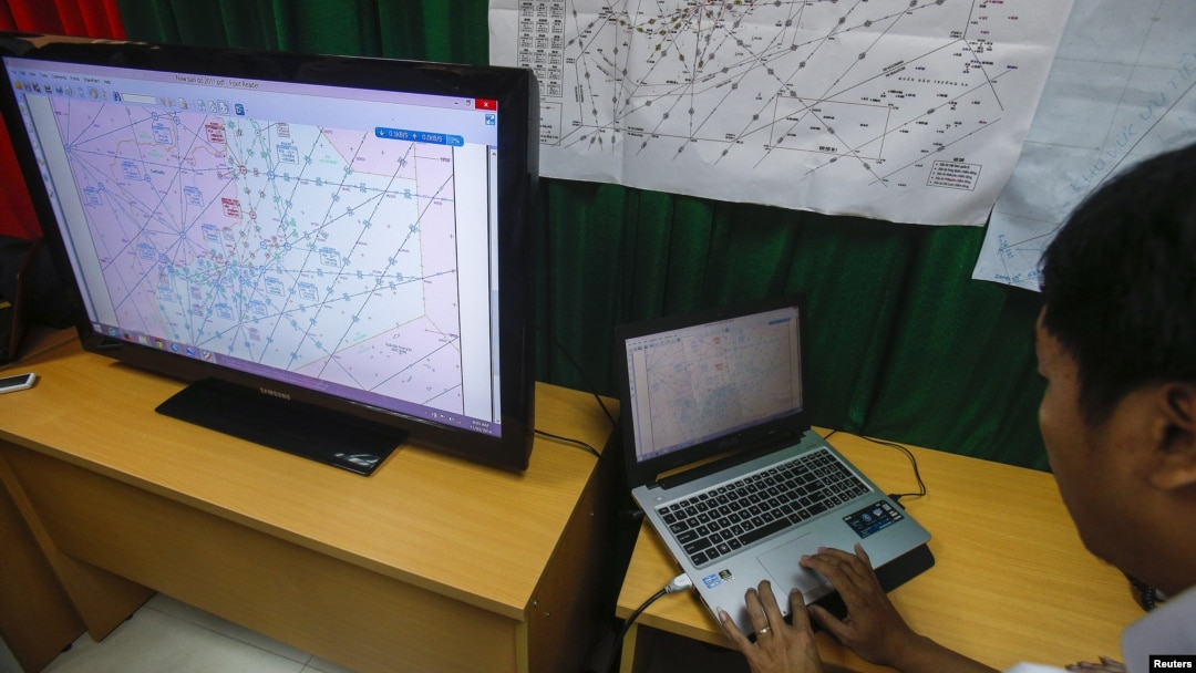 A Vietnamese officer prepares a flight route on a TV screen during a news conference about their mission to find missing Malaysia Airlines flight MH370 at Phu Quoc Airport on Phu Quoc Island, March 11, 2014.