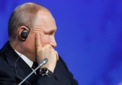 Russian President Vladimir Putin listens during a plenary session of the International Arctic Forum in St. Petersburg, April 9, 2019.