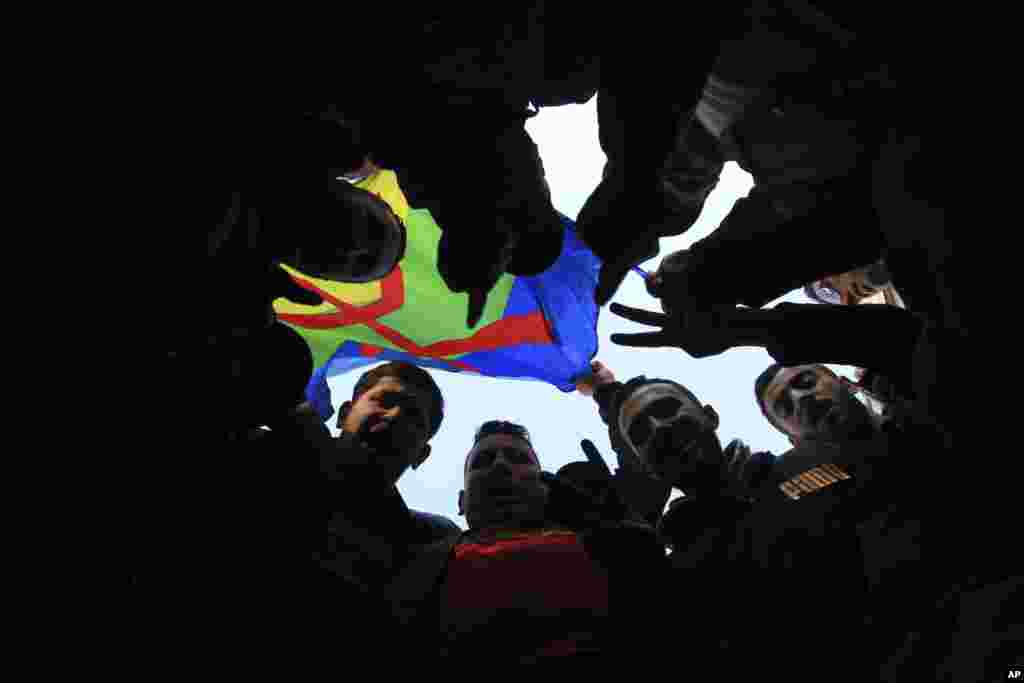 Algerians flash the V sign during a demonstration to protest against the government, in Algiers.