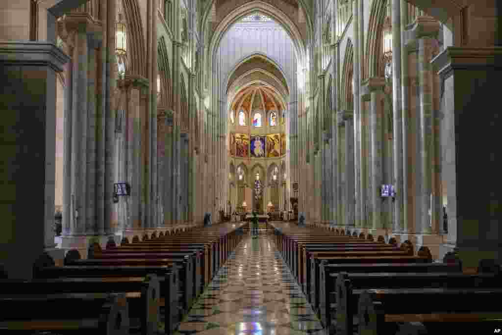 Archbishop Carlos Osoro, background an right, celebrates an Easter Sunday Mass inside an empty Almudena cathedral, in Madrid, Spain.