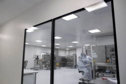 In this Aug. 14, 2020, file photo, laboratory technicians work at the mAbxience biopharmaceutical company on an experimental coronavirus vaccine developed by Oxford University and the laboratory AstraZeneca in Garin, Argentina.
