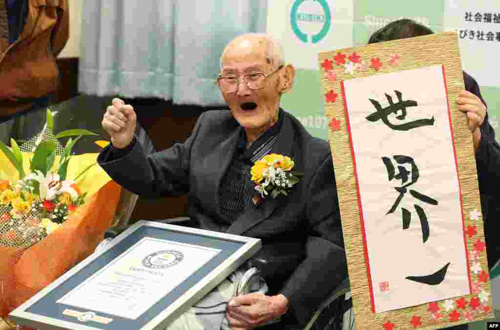 In this Japan Pool picture received via Jiji Press on Feb. 12, 2020, 112-year-old Japanese man Chitetsu Watanabe poses next to calligraphy reading in Japanese 'World Number One' after he was awarded as the world's oldest living male in Joetsu, Niigata prefecture.