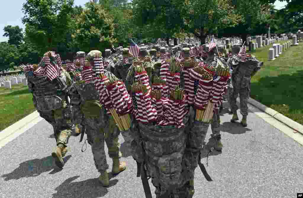 Members of the 3rd U.S. Army Infantry Regiment known as the Old Guard prepare to place flags on every headstone of fallen soldiers at Arlington National Cemetery in Arlington, Virginia, USA, ahead of Memorial Day.