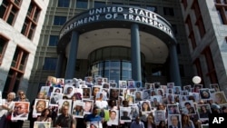 Demonstrators hold pictures of the plane crash victims during a vigil on the six-month anniversary of the crash of a Boeing 737 Max 8, killing 157 people, in Ethiopia on March 10, which has resulted in the grounding hundreds of the planes worldwide,…