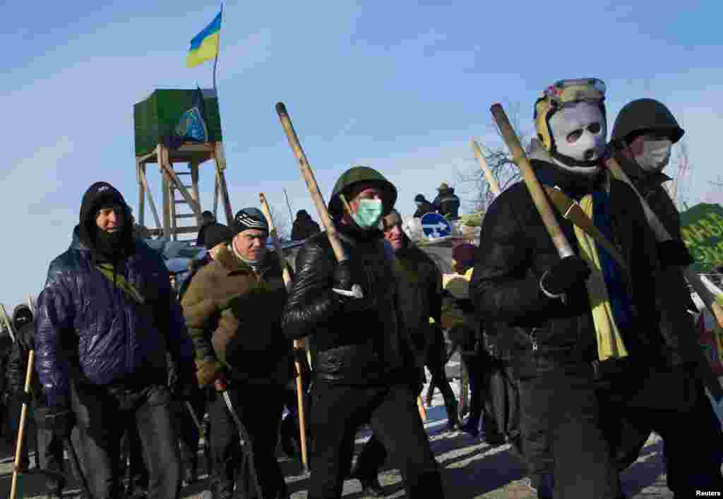 Members of various anti-government paramilitary groups walk in formation during a show of force in Kyiv, Jan. 29, 2014. 