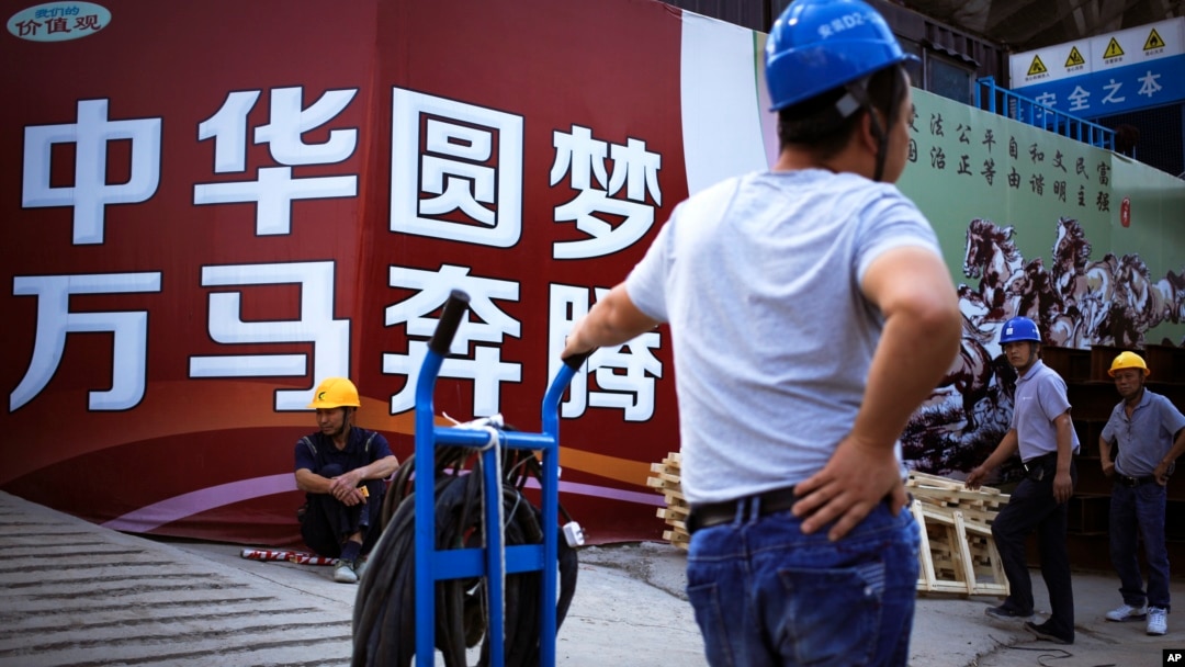 中國工人在北京一處建築工地外展示的中國政府宣傳“中國夢”的廣告看板旁休息。 （2016年9月5日）