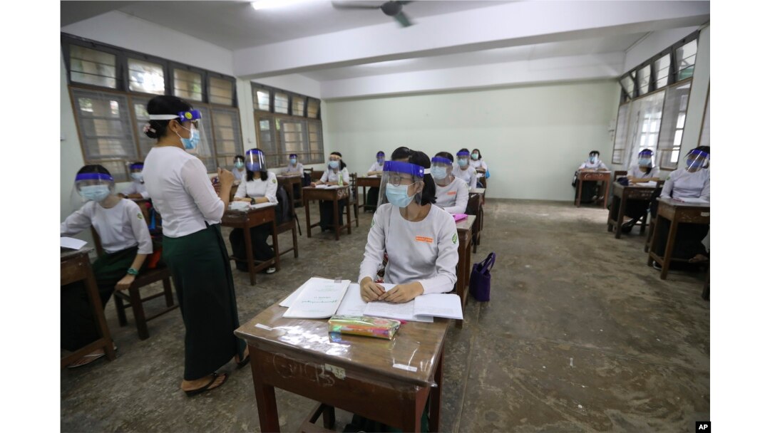 FILE - A teacher and students wearing face shields and masks attend a class at a high school in Yangon, Myanmar, on July 21, 2020. Student enrollment in Myanmar dropped 80% from the beginning of the COVID-19 pandemic in 2020 through 2022, a year after the military took over.