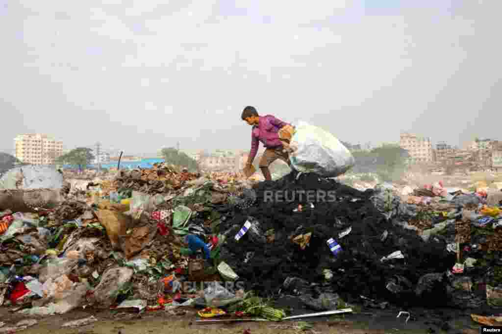 A boy collects materials from waste dumped in the bank of Buriganga River in Dhaka, Bangladesh.