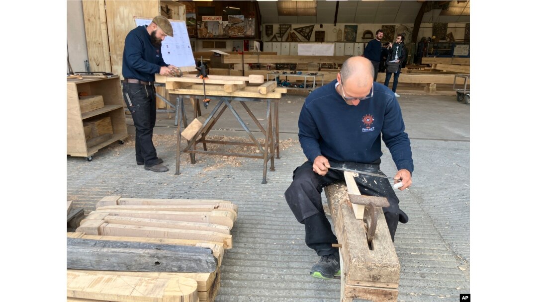 Carpenters work on pieces, part of the new roof for the Notre Dame de Paris cathedral on May, 25, 2023, near Angers, western France. (AP Photo/Jeffrey Schaeffer)
