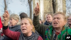Supporters of the government shout slogans outside Moldova's parliament during a rally in Chisinau, Moldova, Nov. 12, 2019. 