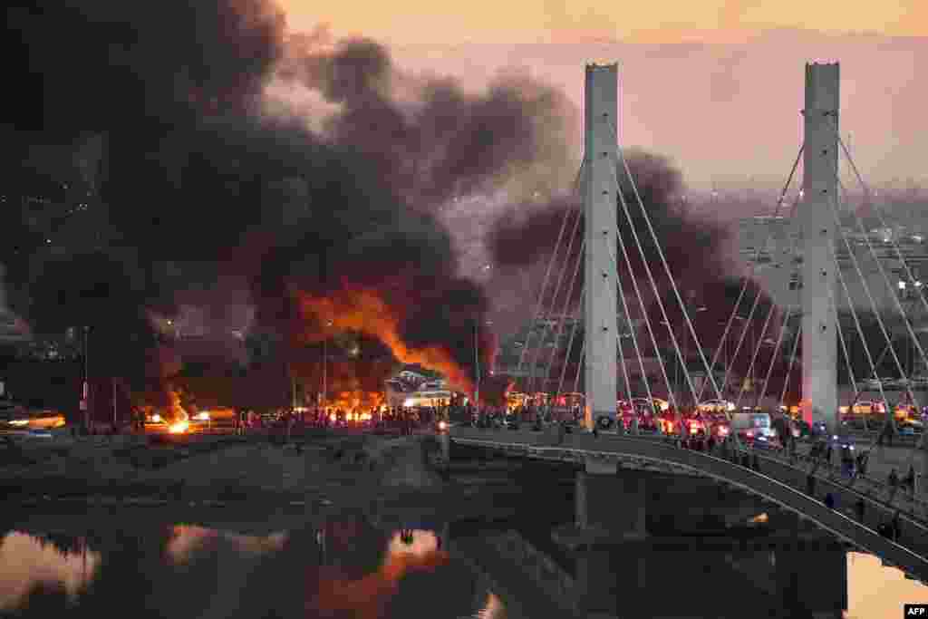 Anti-government demonstrators block a bridge with debris and burning tires in the southern Iraqi city of Nasiriyah.