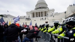 ARCHIVO - Simpatizantes del presidente Donald Trump tratan de abrirse paso a la fuerza al Capitolio en Washington, el 6 de enero de 2021