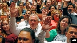 Mormons participate in a long-standing custom called a "sustaining" when Latter-day Saints stand and raise their hands during the twice-annual conference of the Church of Jesus Christ of Latter-day Saints, Oct. 6, 2018, in Salt Lake City. 