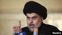 FILE - Iraqi Shi'ite radical leader Muqtada al-Sadr delivers a sermon to worshippers during Friday prayers at the Kufa mosque near Najaf, Dec. 11, 2015.