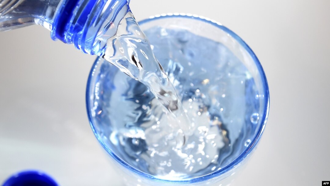 FILE - A glass is filled in with drinking water. 