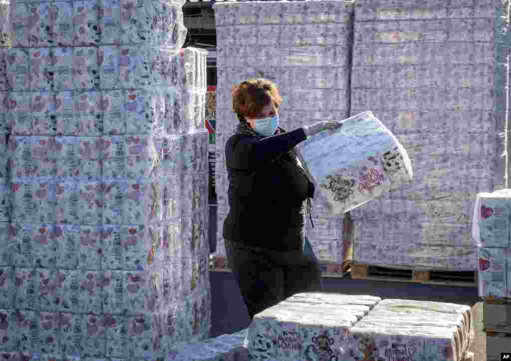 A woman piles up toilet paper at a a 'toilet paper drive in' in a parking spot in Dornburg, some 60 km west of Frankfurt, Germany.