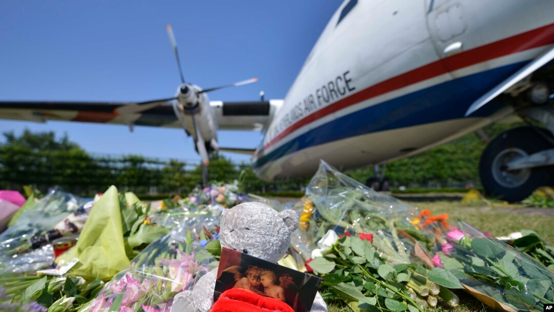 Flowers and a teddy bear are placed in front of a plane prior a ceremony to mark the return of the first bodies of passengers and crew killed in the downing of Malaysia Airlines Flight 17, Eindhoven military air base, July 23, 2014.