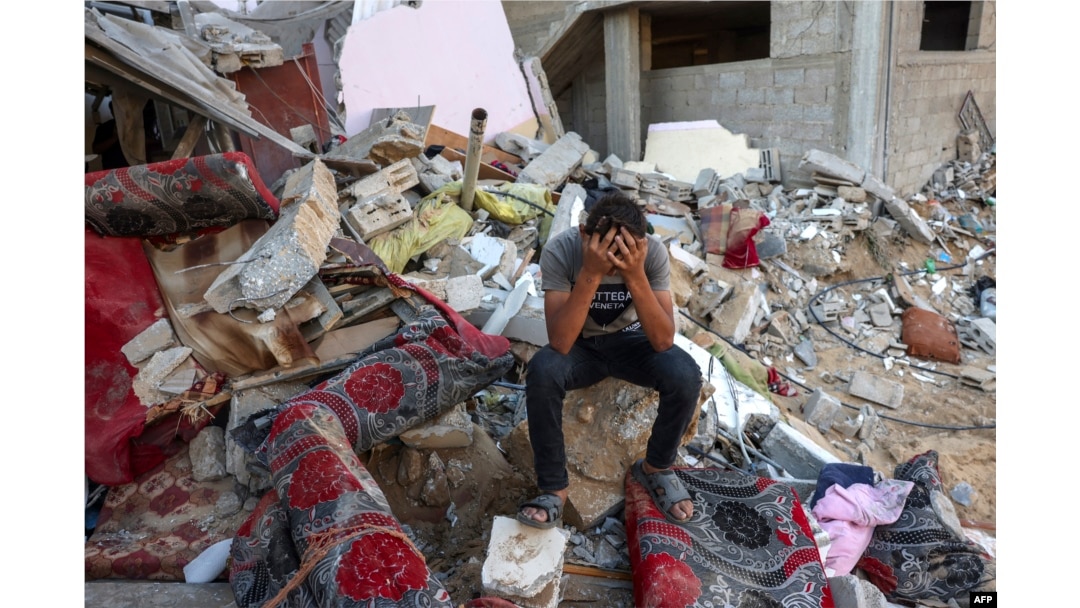 A Palestinian youth reacts as he sits on the rubble of a destroyed home following an Israeli military strike on the Rafah refugee camp, in the south of Gaza Strip, Oct. 15, 2023, amid battles between Israel and the Palestinian Islamist group Hamas.