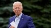 El exvicepresidente del candidato presidencial demócrata Joe Biden coloca una tarjeta en el bolsillo de su chaqueta mientras habla en un evento de campaña en Michigan.