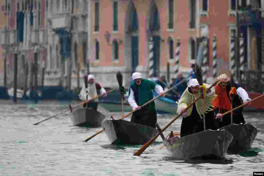 Men dressed as "La Befana", an imaginary old woman who is thought to bring gifts to children, row boats down the Grand Canal in Venice, Italy, during the festival of Epiphany.