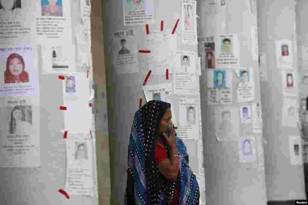 A woman waits for news of her relative, a garment worker, who is missing after the collapse of Rana Plaza building, in front of missing people posters in Savar, Bangladesh, April 30, 2013.