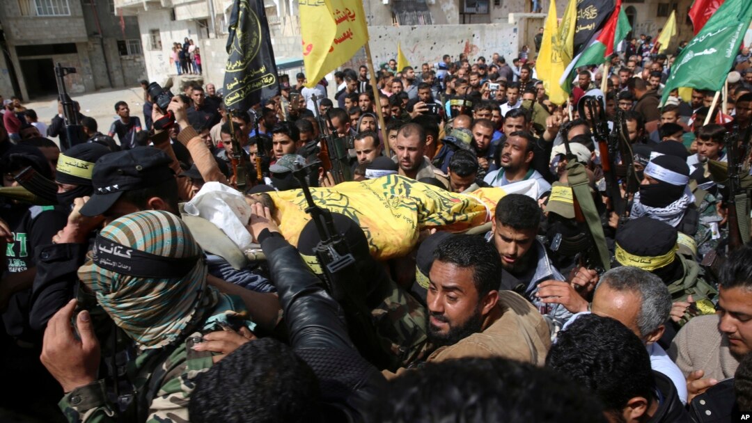 Relatives and masked Palestinian militants carry the body of Hamdan Abu Amsha, 23, during his funeral in Beit Hanoun, Gaza Strip, March 31, 2018.