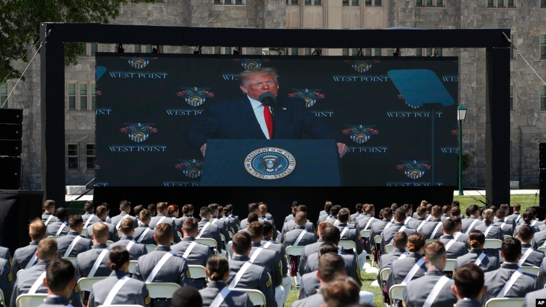 A screen displays President Donald Trump as he speaks to over 1,110 cadets in the Class of 2020 at a commencement ceremony on the parade field, at the United States Military Academy in West Point, N.Y., June 13, 2020.