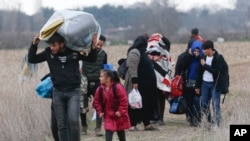 Migrants walk near Pazarkule at the Turkish-Greek border, March 5, 2020. 
