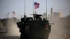 FILE - A convoy of U.S. forces armored vehicles drives near the village of Yalanli, on the western outskirts of the northern Syrian city of Manbij, March 5, 2017.
