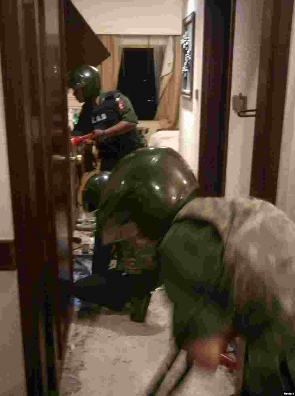 Soldiers inspect a room where an explosion occurred at Traders Hotel in central Rangoon, Burma, Oct. 15, 2013.