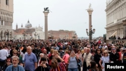 FILE - Tourists are seen at St. Mark's Square in Venice, Italy, April 15, 2018.