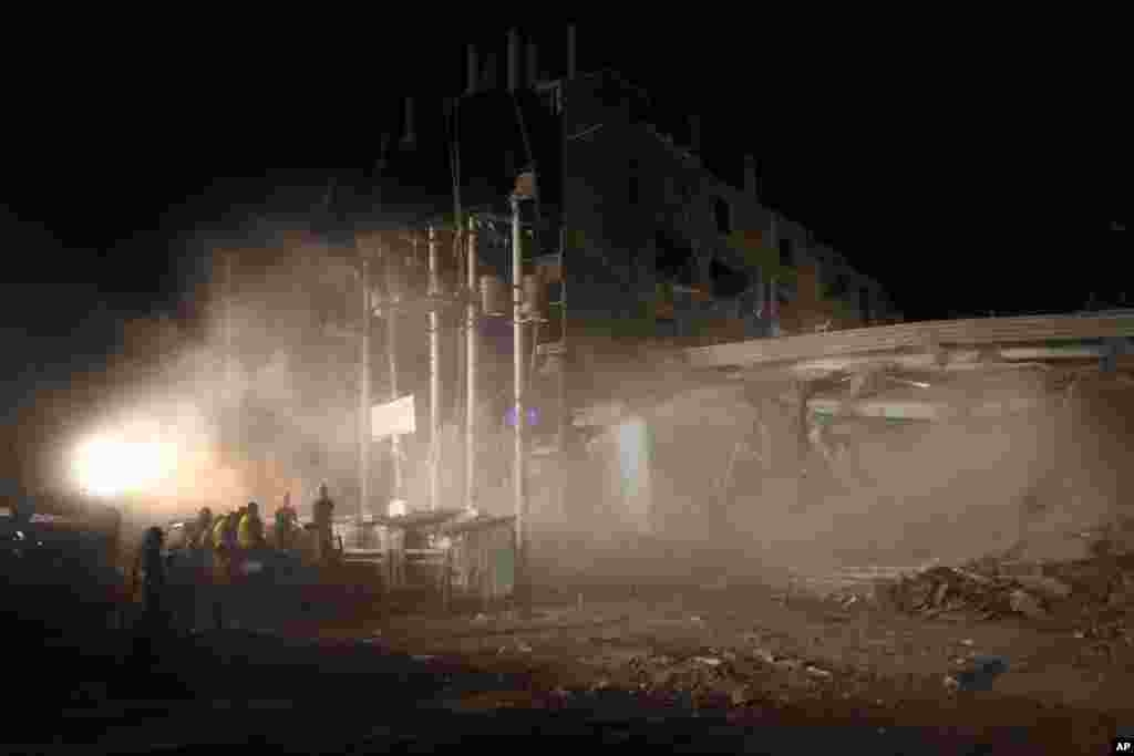 Firefighters and army personnel are blanketed in thick dust after part of the garment factory building collapses after being dislodged as part of the clearing process in Savar, near Dhaka, April 29, 2013.
