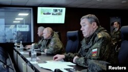 El presidente ruso, Vladimir Putin, centrado en el centro, observa el desarrollo de las maniobras militares Vostok-2022, junto al ministro de Defensa, Sergei Shoigu, y al jefe del jefe del Estado Mayor, el general Valery Gerasimov, en primer plano, el 6 de septiembre de 2022.