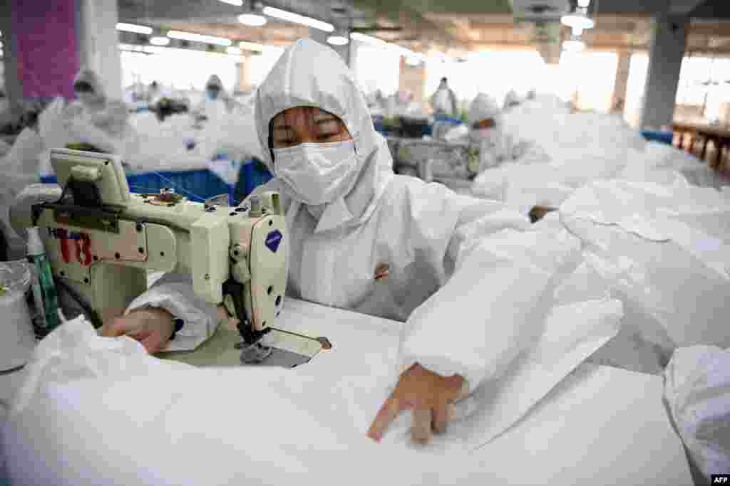 Workers sew hazardous material suits to be used in the COVID-19 outbreak at the Zhejiang Ugly Duck Industry garment factory in Wenzhou, China.