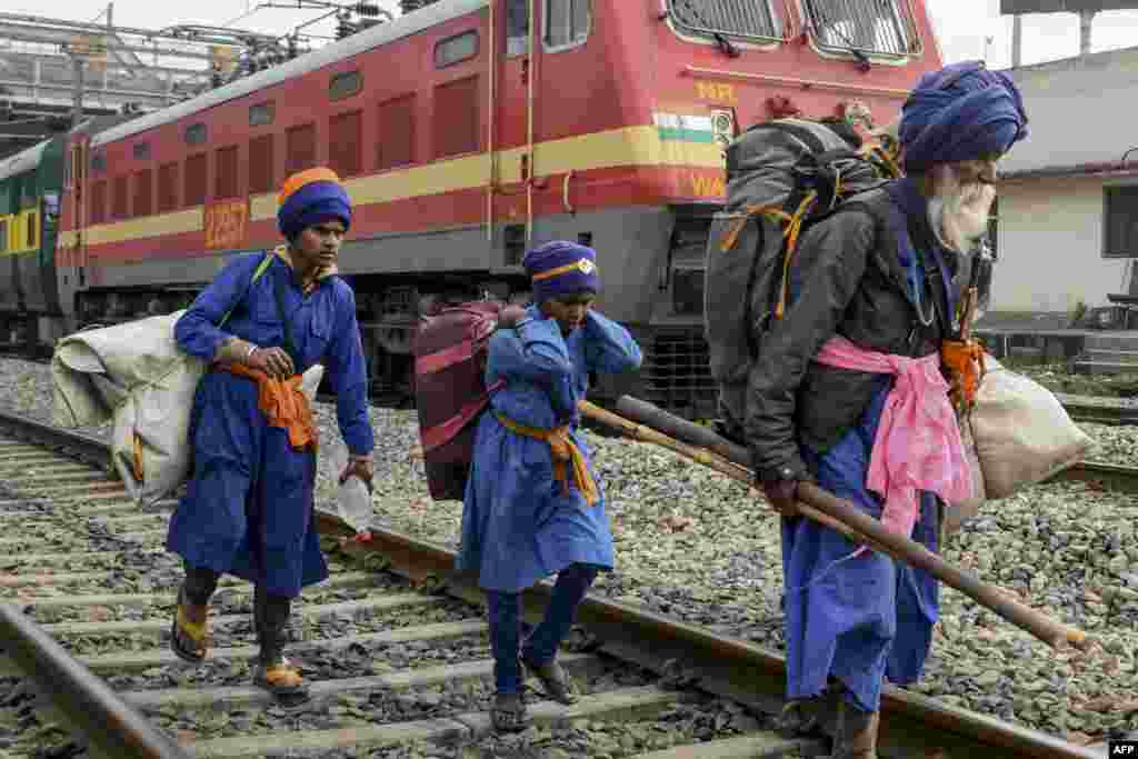 Passengers carry their belongings near the railway station in Amritsar, India, as activists of Communist Party of India Marxist (CPIM) block train tracks during a nationwide general strike called by trade unions aligned with opposition parties to protest the government's economic policies.