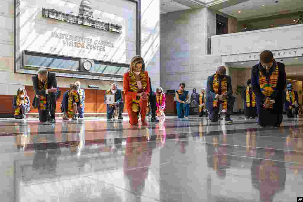 House Speaker Nancy Pelosi of Calif., center, and other members of Congress, kneel and observe a moment of silence at the Capitol's Emancipation Hall, on Capitol Hill in Washington, reading the names of George Floyd and others killed during police interactions. 