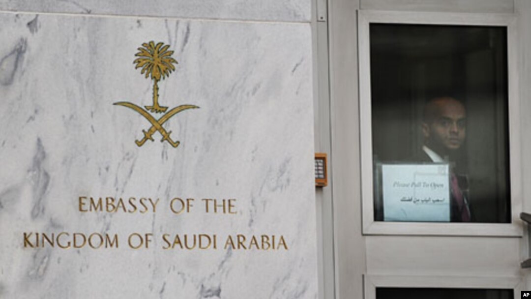 An embassy staffer peers through a glass door at an entrance of the Saudi Arabian embassy in Washington, DC, October 11, 2011.