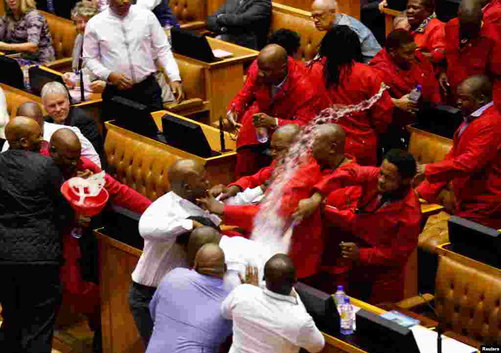 Ketua parpol EFF di Afrika Selatan, Julius Malema dan anggota partai EFF bentrok dengan petugas keamanan saat diusir dari gedung parlemen di Cape Town.