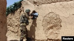 阿富汗國民軍士兵在阿富汗赫爾曼德省巴巴吉一處哨所陣地嚴陣以待。