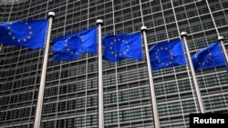 FILE - European Union flags fly in front of the European Commission headquarters in Brussels, October 12, 2012.