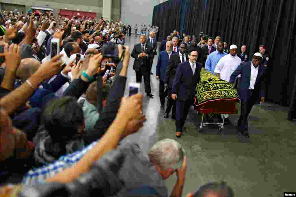 Worshipers and well-wishers take photographs as the casket with the body of the late boxing champion Muhammad Ali is brought for his jenazah, an Islamic funeral prayer, in Louisville, Kentucky, USA.