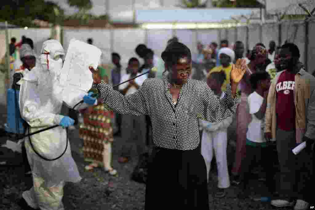 A woman being discharged from the Island Clinic Ebola treatment center is sprayed with disinfectant, Monrovia, Liberia, Sept. 30, 2014.