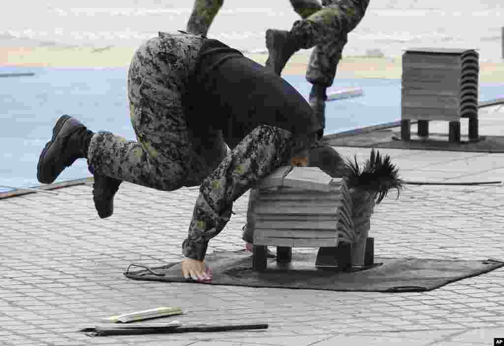 Seorang tentara Korea Selatan menunjukkan kemampuan beladirinya dengan memecah tumpukan semen dengan kepalanya di Seoul.