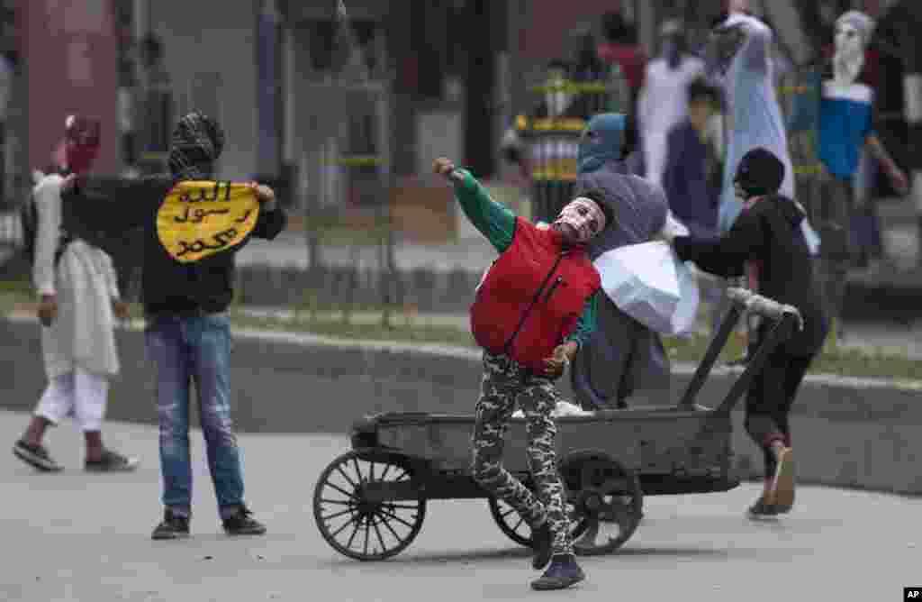 Pengunjuk rasa Muslim Kashmir melempar batu ke arah petugas keamanan saat melancarkan protes di Srinagar, daerah Kashmir yang dikuasai India.