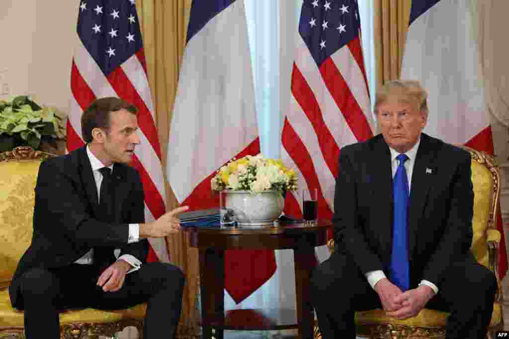 U.S. President Donald Trump (R) and France's President Emmanuel Macron react as they talk during their meeting at Winfield House, London.